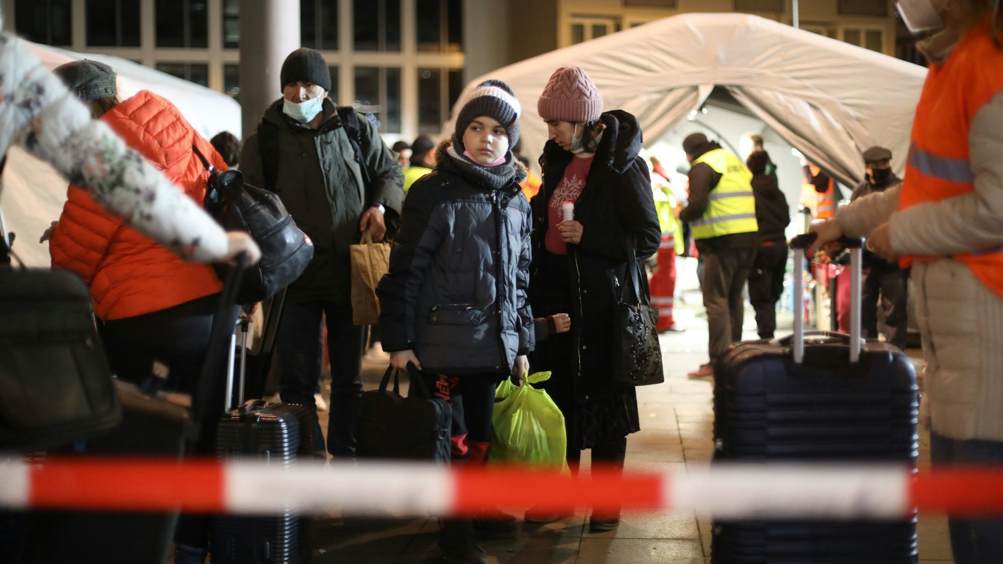 Mehrere Geflüchtete kommen nachts am Breslauer Platz an der Auffangstation für Geflüchtete aus der Ukraine an.