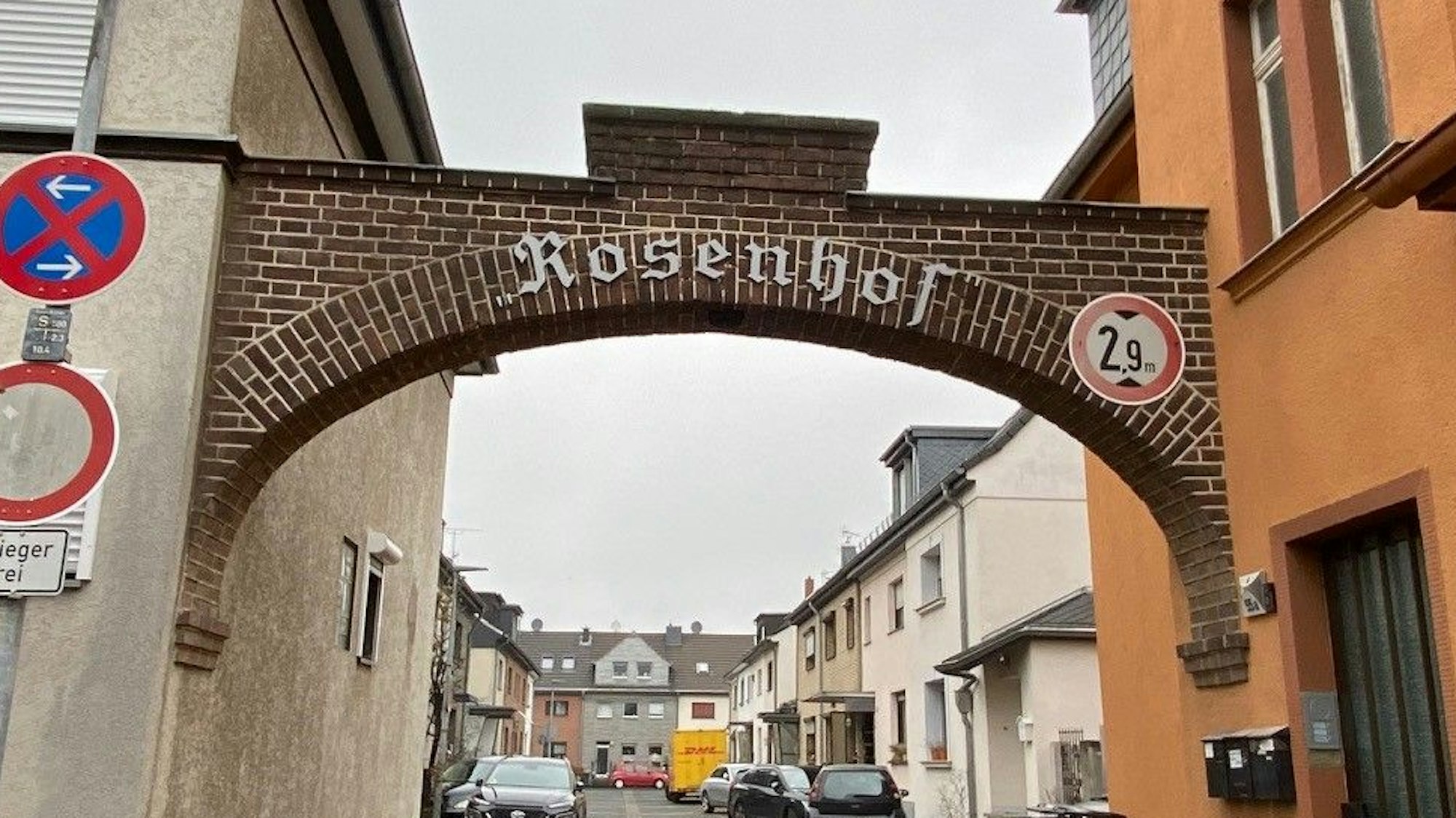 Einen gemauerten Torbogen ziert ein silber-grauer Schrifzug mit „Rosenhof“.