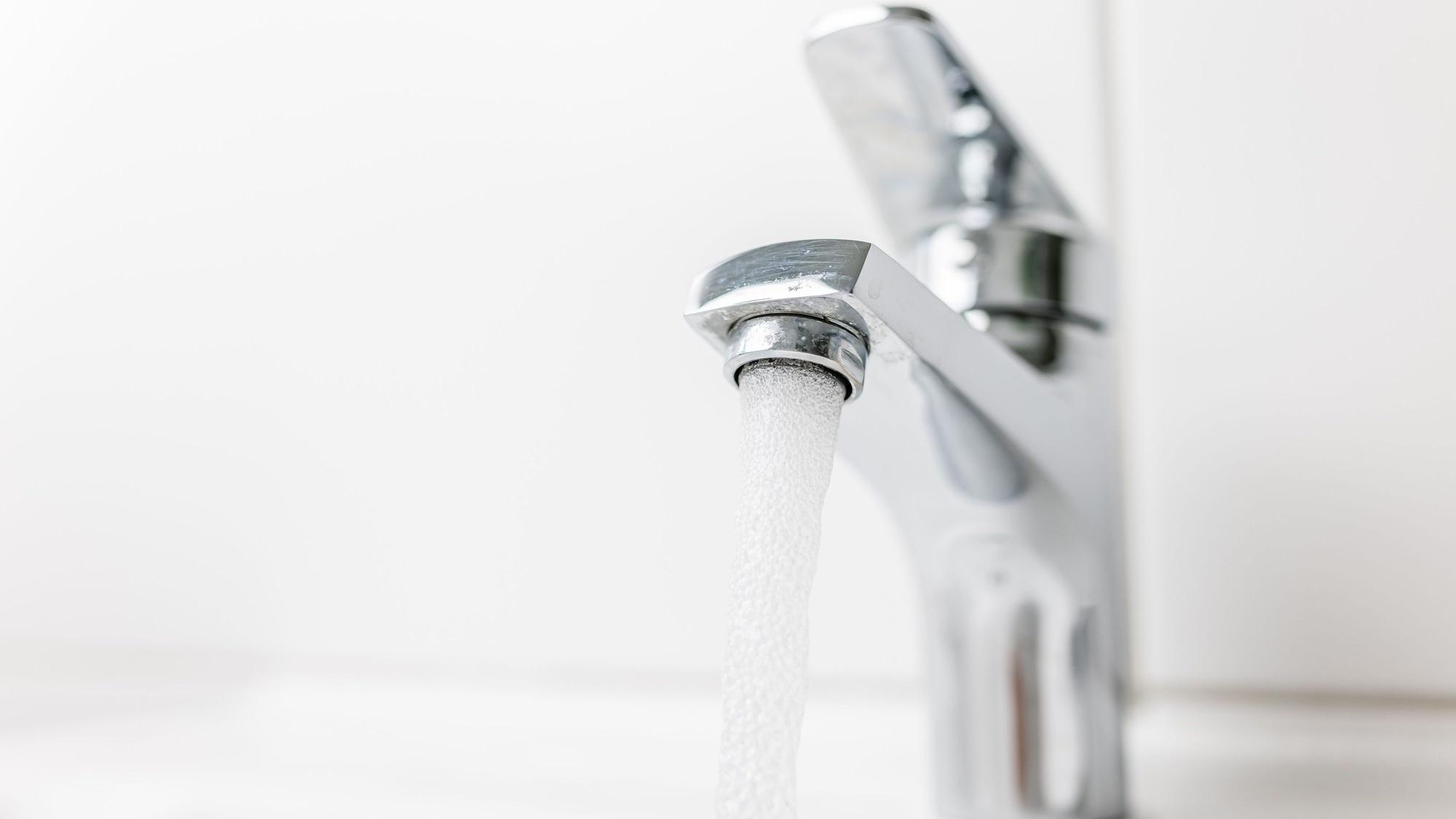 Wasser fließt aus einem Wasserhahn.