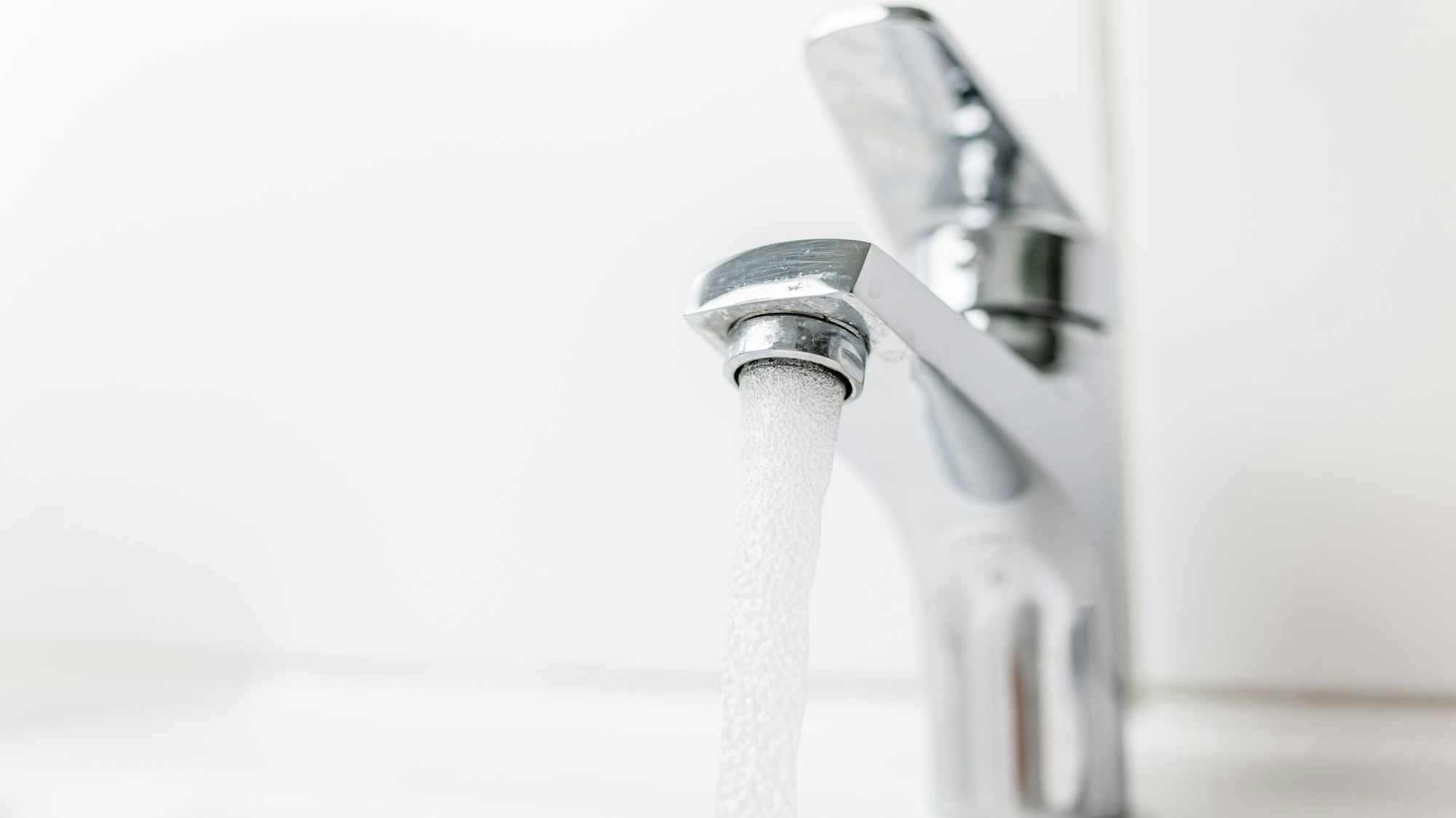 Wasser fließt aus einem Wasserhahn.