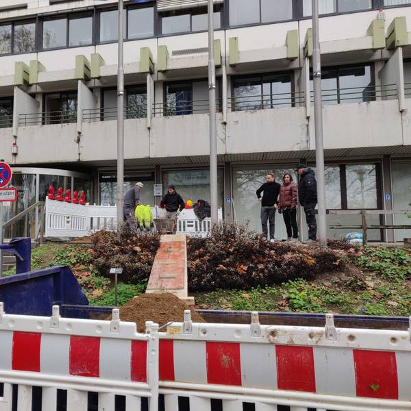 Baugitter vor dem Leichlinger Rathaus-Eingang, wo Arbeiter Erde für ein Fundament ausheben.