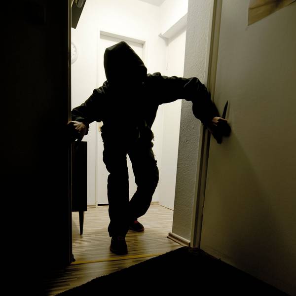 Ein mit einem Messer bewaffneter Mann schleicht durch eine Wohnung. Das Foto wurde gestellt.