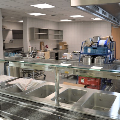 Eine Kantinenküche mit leeren Regalen.