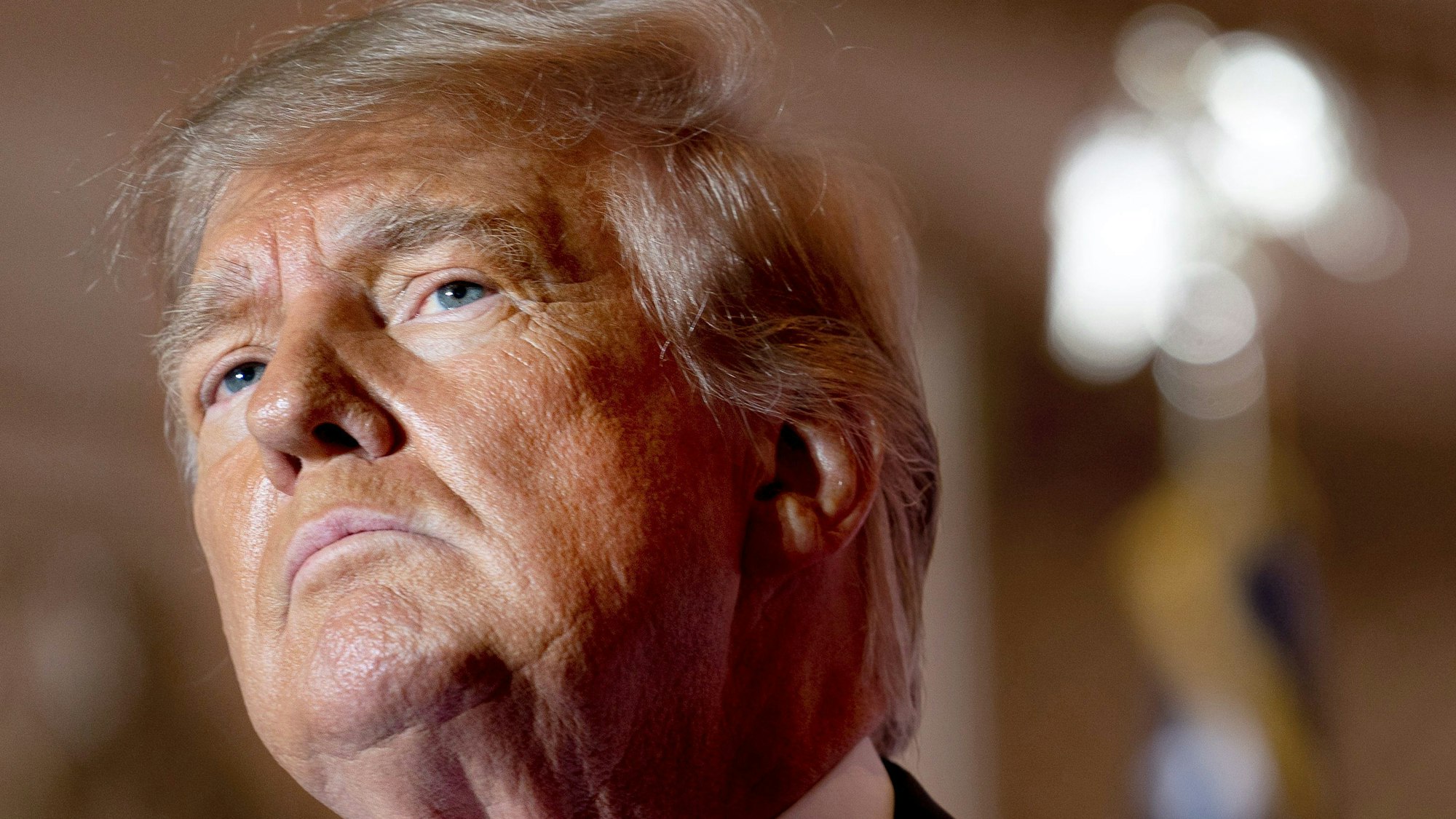 Donald Trump, ehemaliger US-Präsident, spricht in seinem Anwesen Mar-a-Lago. Er schaut ernst nach oben.