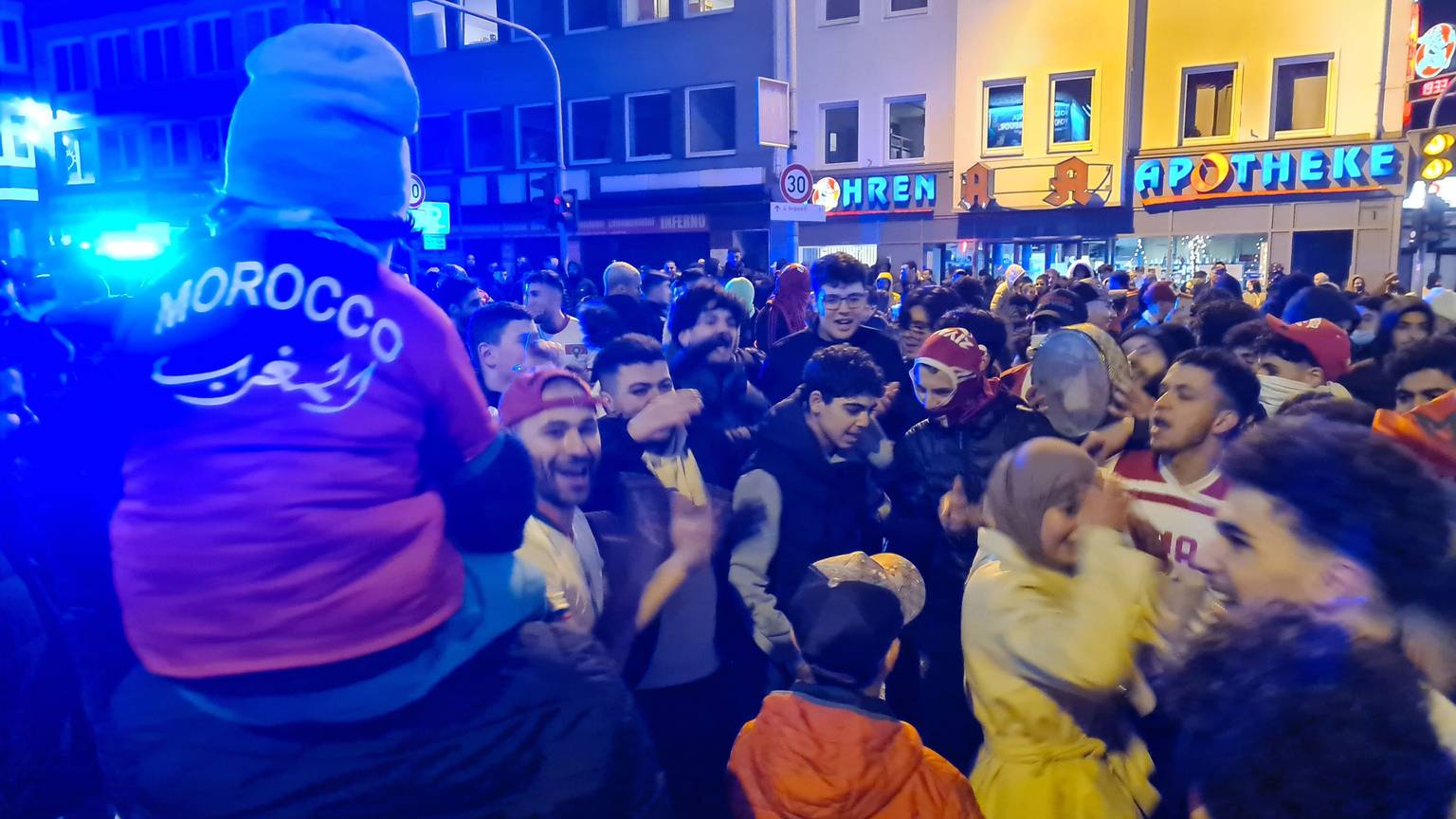 Das Bild zeigt feiernde Fans nach dem Sieg Marokkos gegen Spanien bei der Fußball-WM in Bergheim.