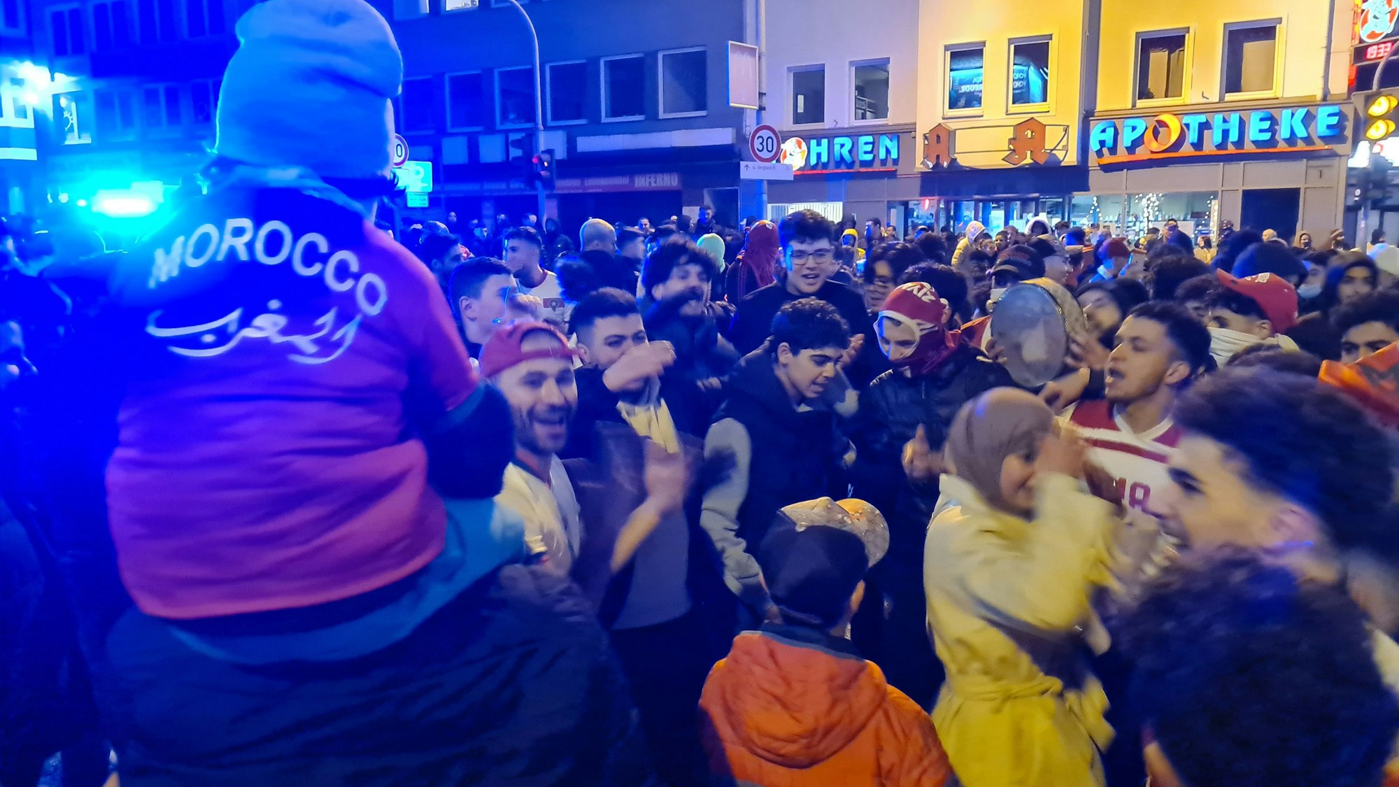 Das Bild zeigt feiernde Fans nach dem Sieg Marokkos gegen Spanien bei der Fußball-WM in Bergheim.