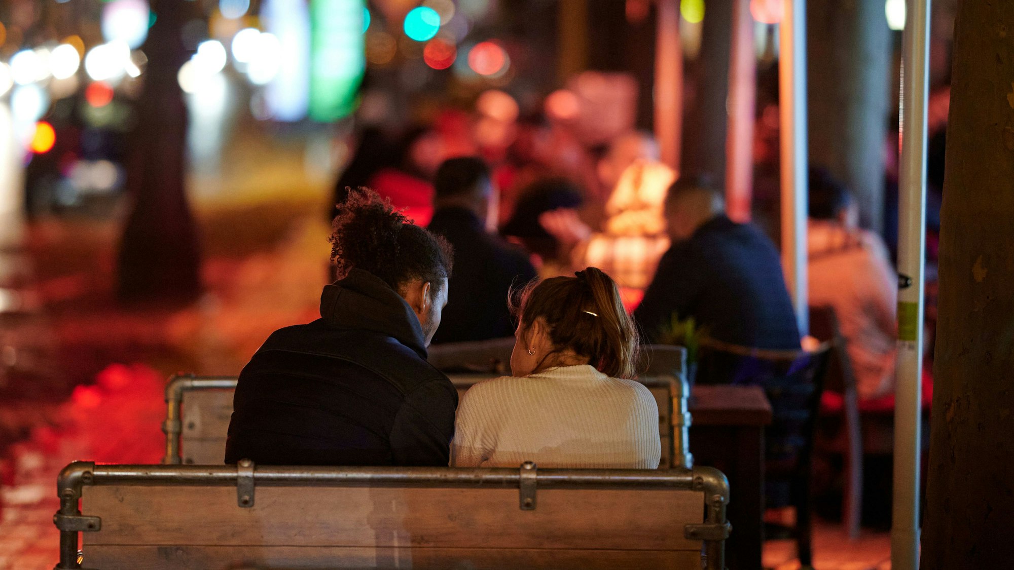 Menschen sitzen im Außenbereich einer Gaststätte.