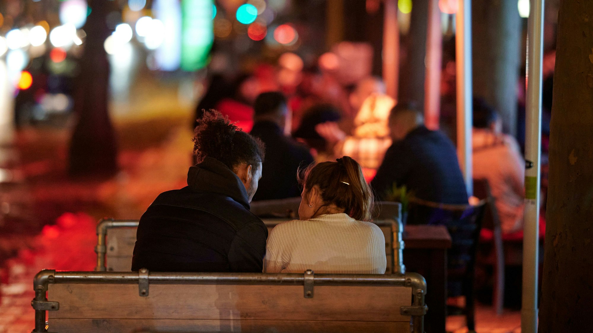 Menschen sitzen im Außenbereich einer Gaststätte.