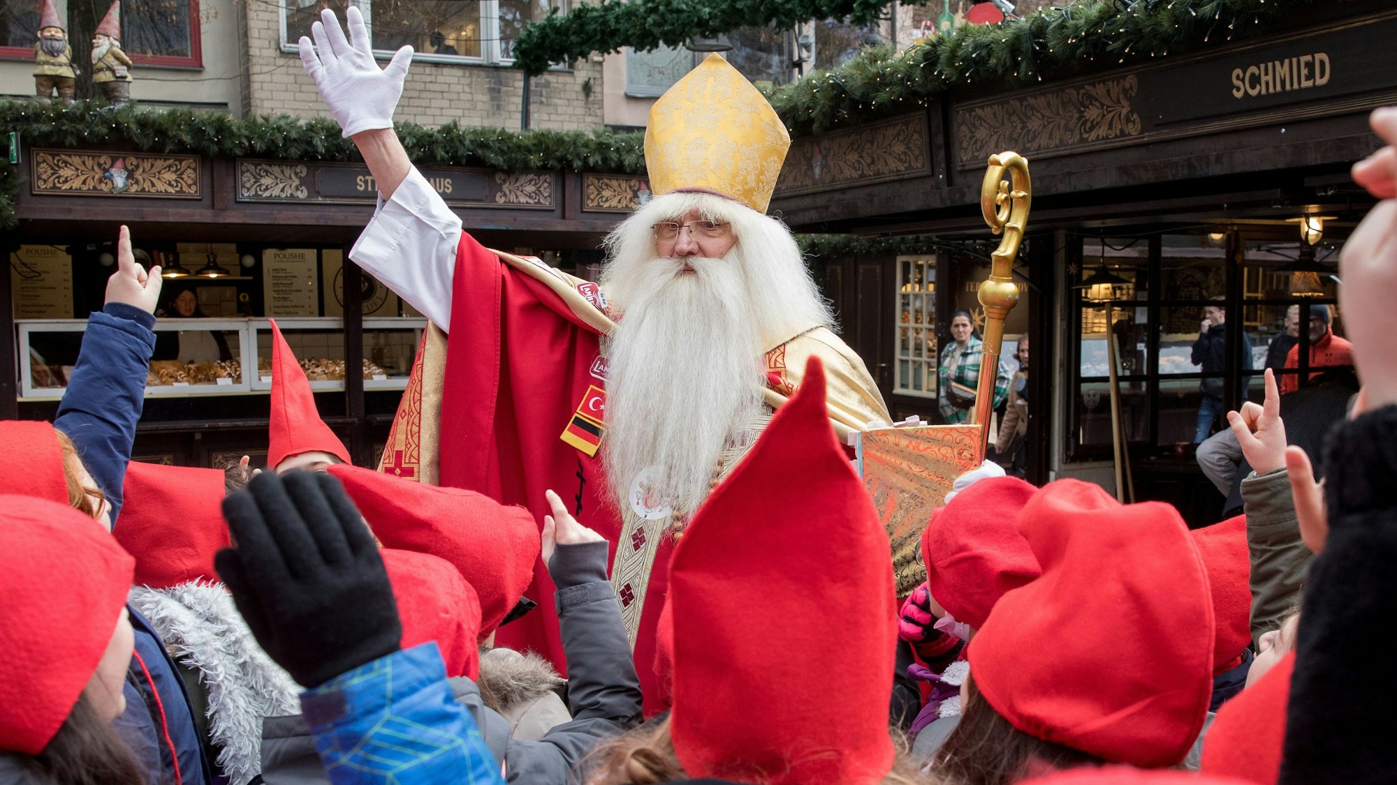 Nikolausdarsteller Wolfgang Kimmig-Liebe trifft auf dem Weihnachtsmarkt am Alter Markt Kinder.
