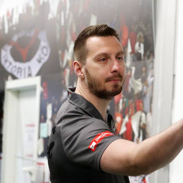 Darts-Profi Florian Hempel im Vip-Zelt des FC Viktoria Köln. Er hat gerade einen Dart-Pfeil geworfen. Der Pfeil fliegt vor ihm.