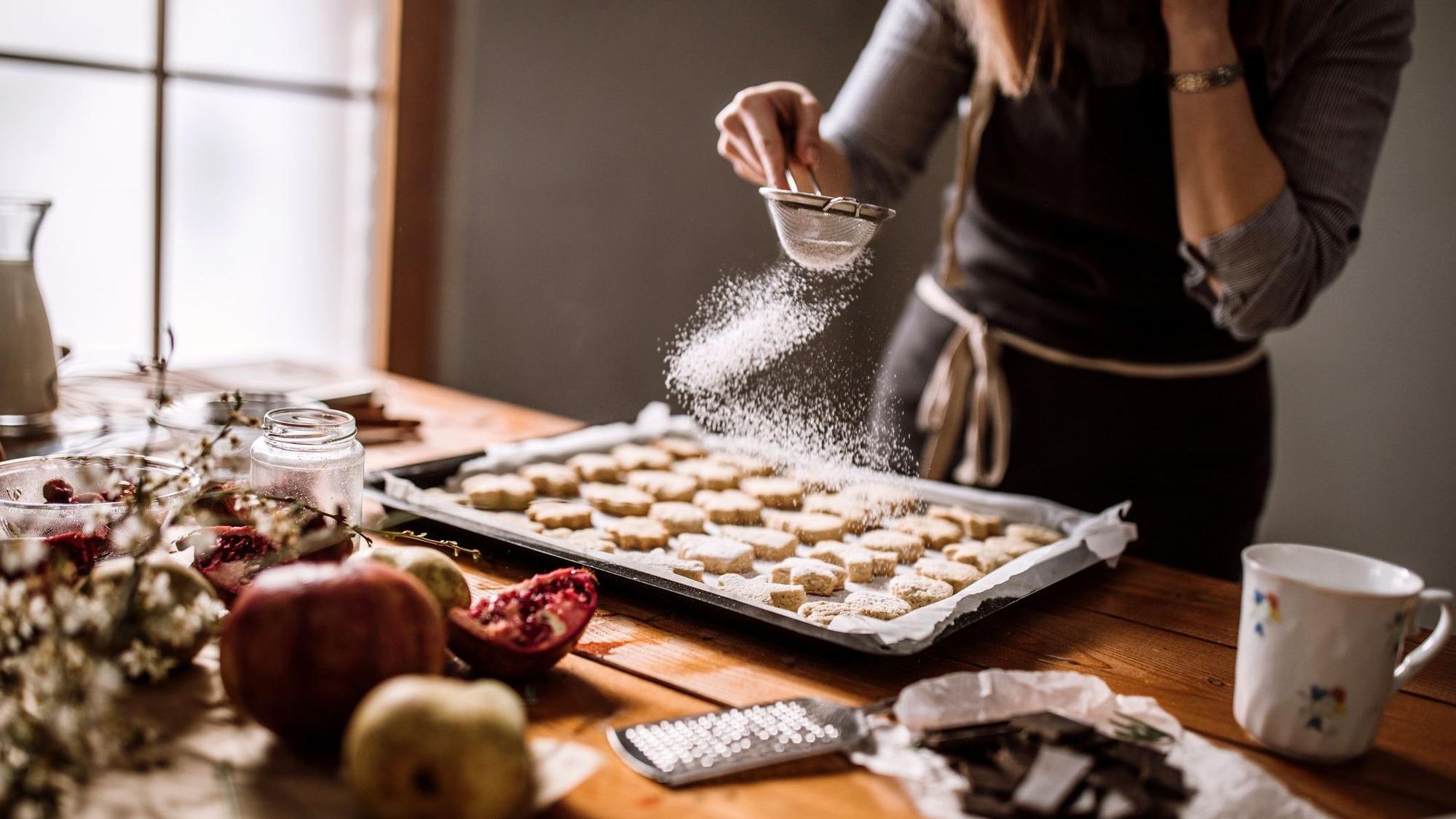 Woman Powdering Fresh Baked Gingerbread Cookies With Sugar