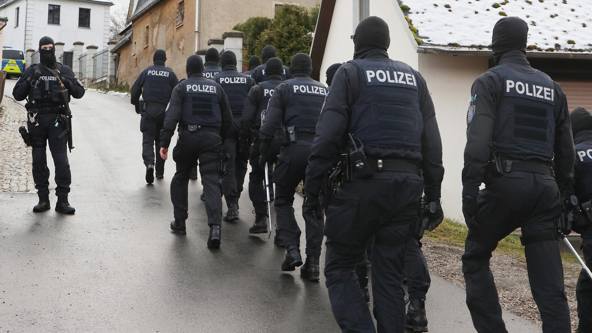 Einsatzkräfte der Polizei laufen zum Jagdschloss Waidmannsheil, während der Durchsuchung durch die Polizei.