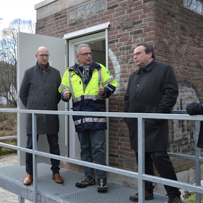 Drei Männer stehen auf einem Metallsteg, der als Zugang für das Pegelhäuschen in Gemünd an der Urft dient.
