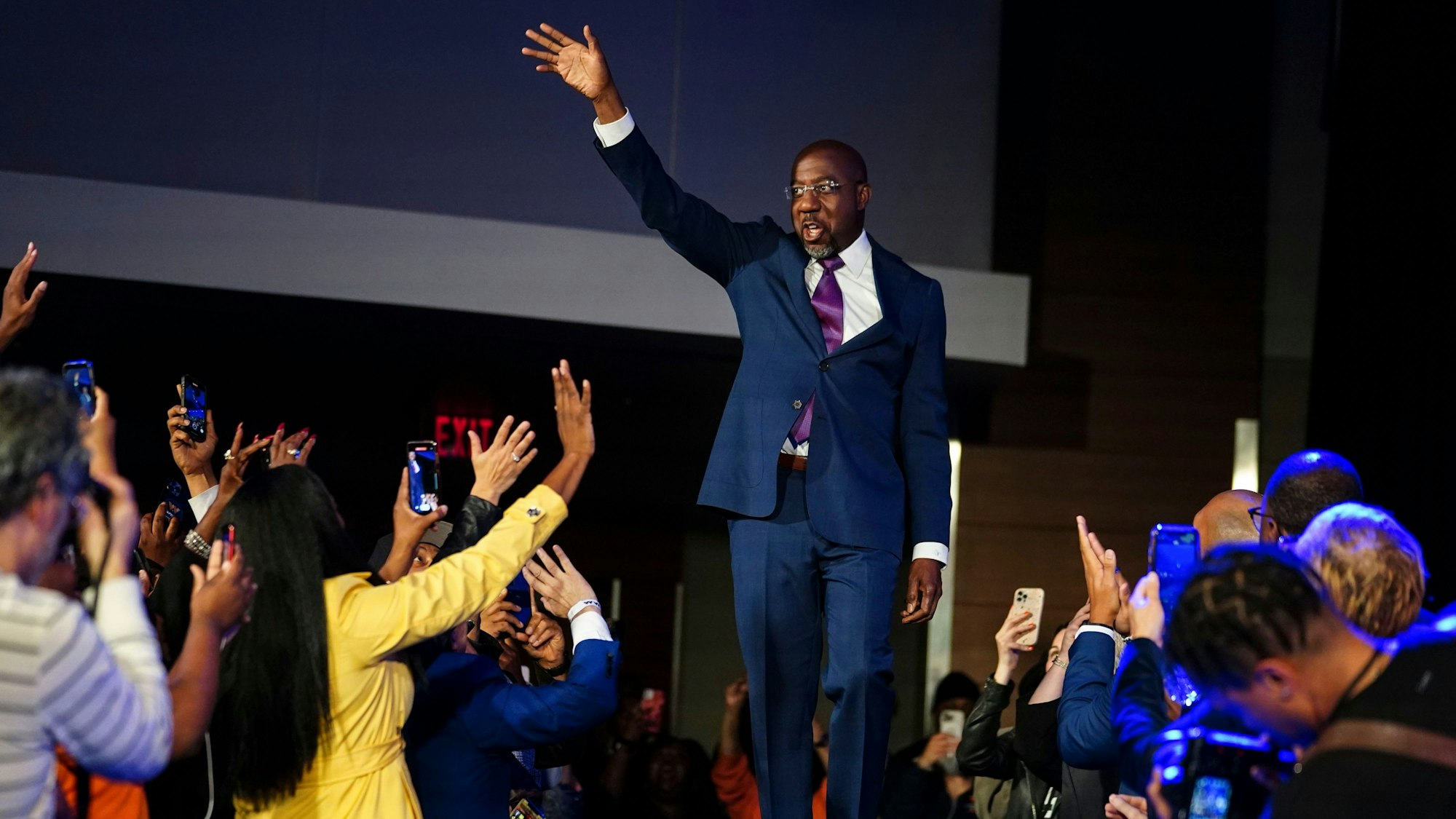 Der demokratische Senator Raphael Warnock winkt während einer Party in der Wahlnacht vom 6. Dezember seinen Unterstützern.