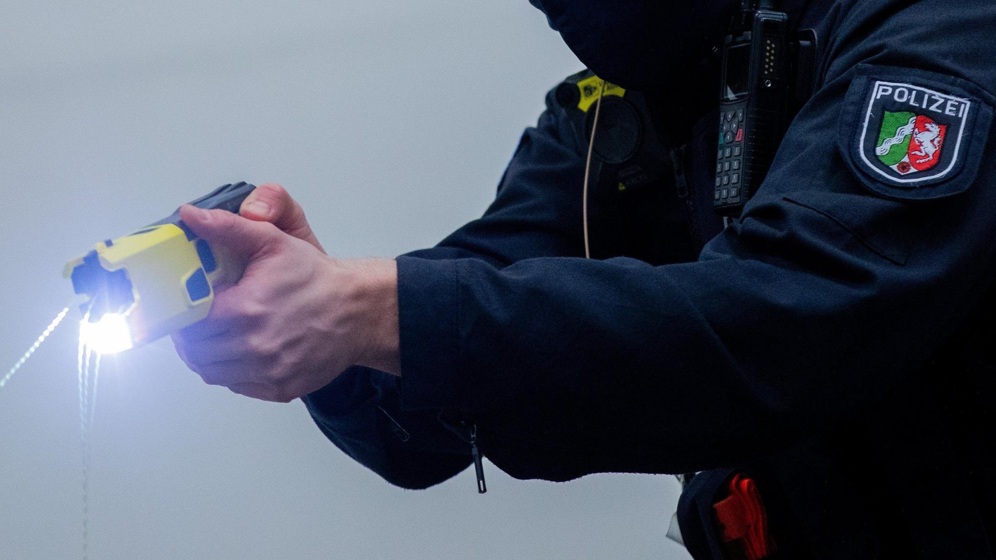 Ein Polizeibeamter demonstriert einen Schuss mit einem Distanz-Eelektroimpulsgerät (DEIG).