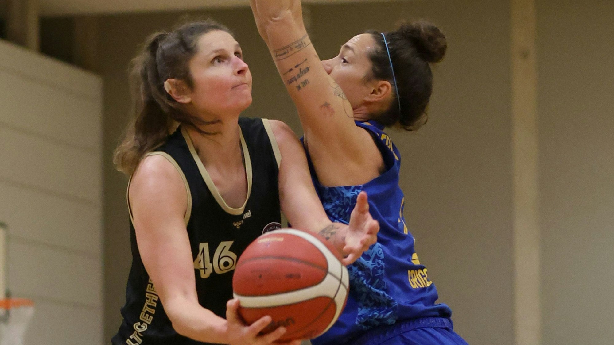Romy Bär von den Rheinland Lions hält den Basketball in der Hand und versucht gegen ihre Gegnerin von Alba Berlin einen Korb zu erzielen.