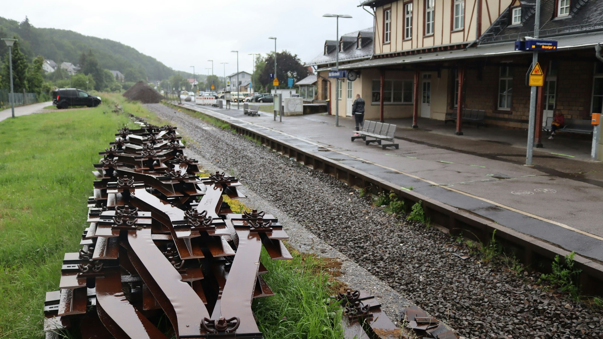 Der Bahnhof Bad Münstereifel an einem regnerischen Tag. Es fehlen infolge der Flut die Gleise, diese liegen aufgestapelt im Vordergrund des Bildes.
