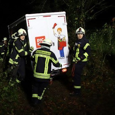 Feuerwehrleute stützen einen Van des Lieferdienstes Picnic in einer steilen Böschung.