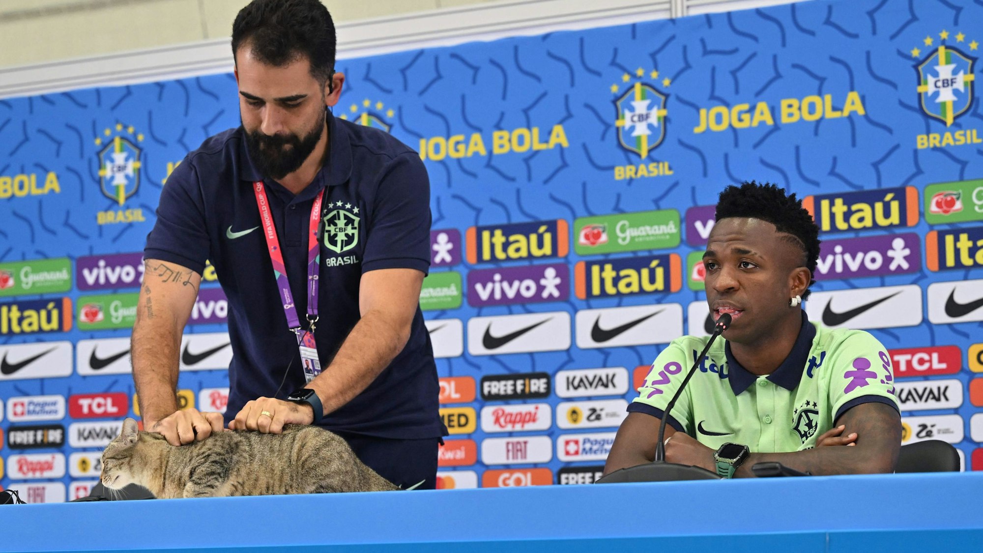 Vinicius Rodrigues, der Sprecher der brasilianischen Fußball-Nationalmannschaft greift eine Katze am Fell.