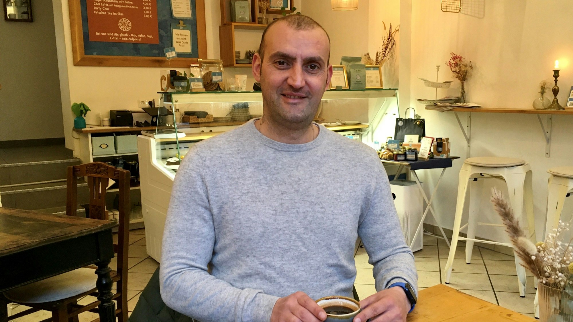 Rocco Conte sitzt in einem Café.