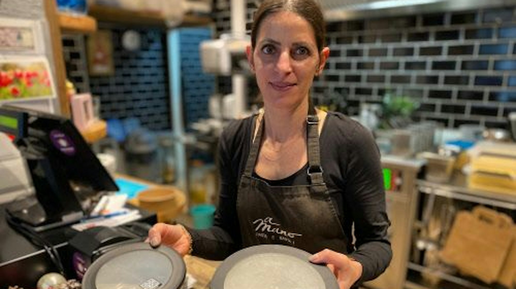 Sophie Gerasis in der Küche ihres Brühler Restaurants „A Mano Pasta e Basta“. Sie füllt die Pasta, Salate und Desserts in mikrowellentaugliche Kunststoffboxen eines Mehrweggeschirr-Anbieters.