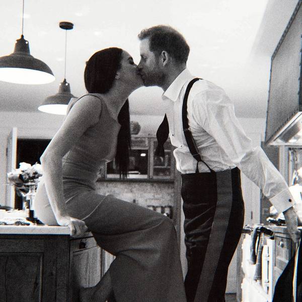 Prinz Harry und Herzogin Meghan küssen einander in einer Küche.