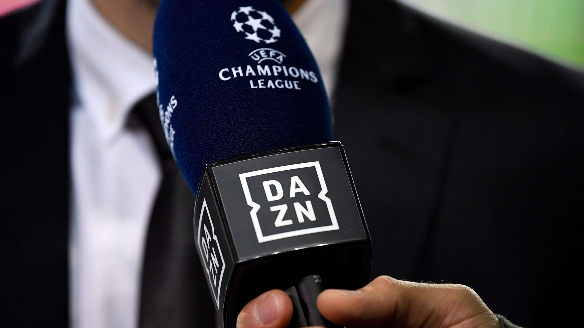 Ein Reporter hält ein Mikrofon des Streamingdienstes DAZN während eines Interviews fest.