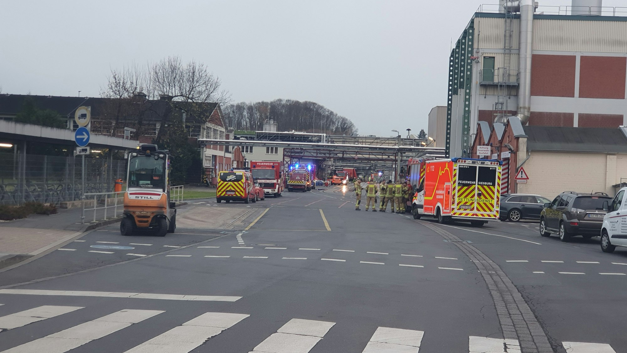 Feuerwehrwagen und Rettungswagen stehen vor einer Produktionshalle des Siegwerks.