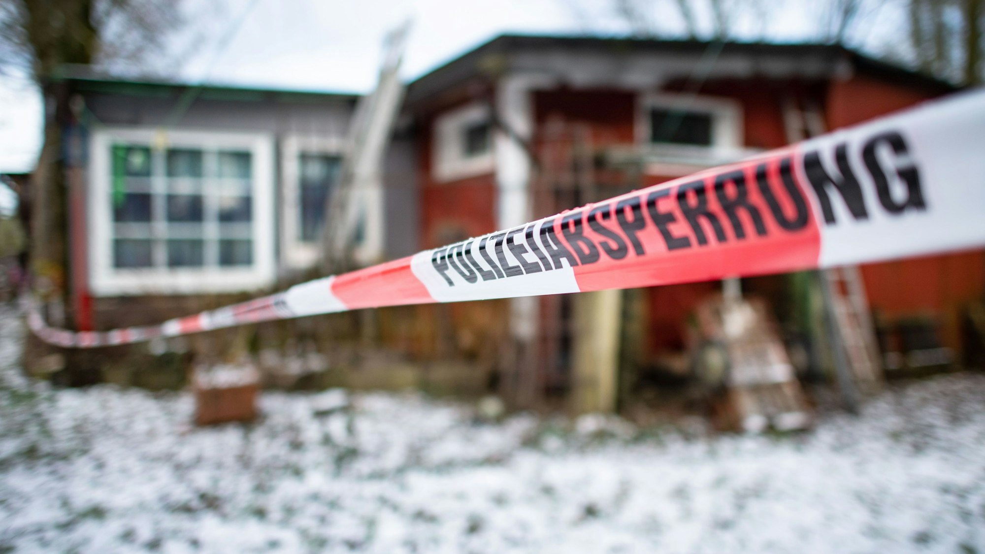 Polizeiabsperrung steht auf einem Absperrband der Polizei, die das Gebäude auf dem Campingplatz Eichwald, eingrenzt.