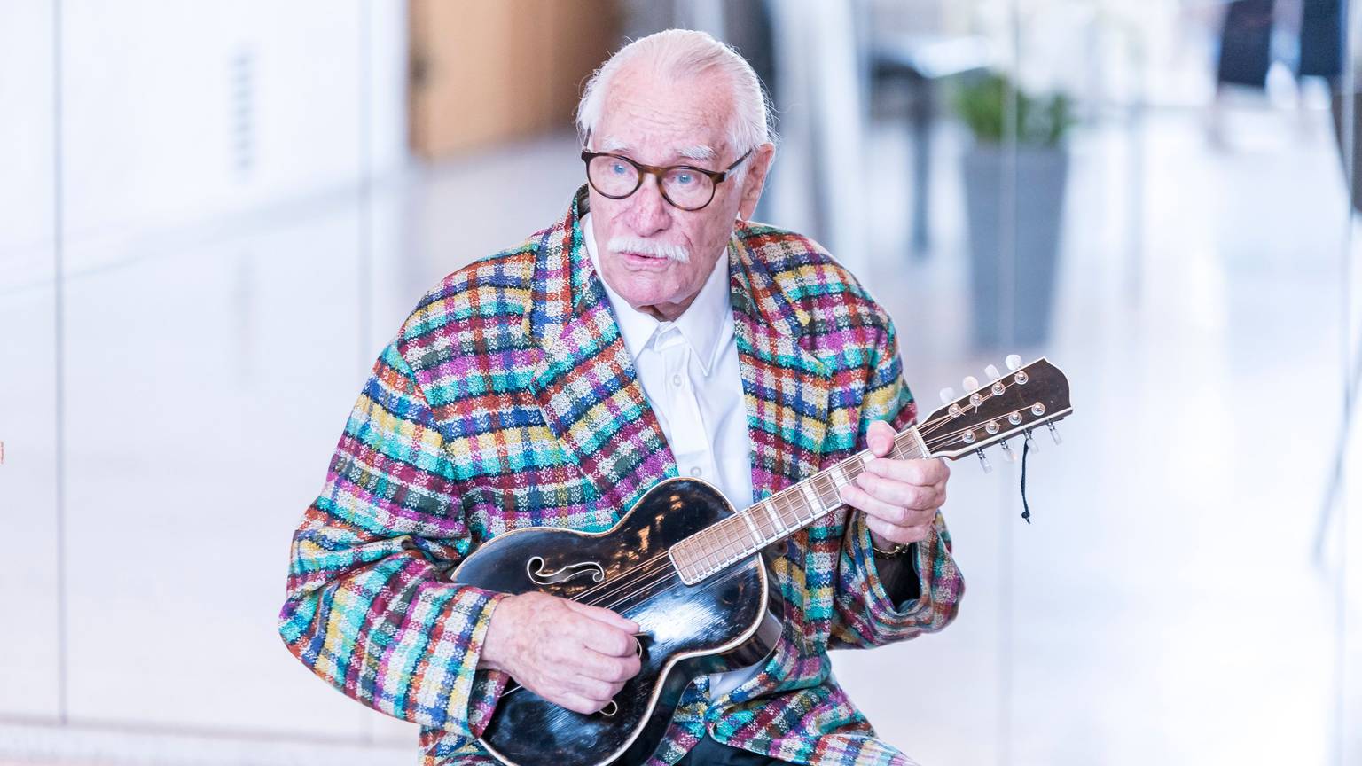 Hans Süper hölt eine Gitarre in seiner Hand
