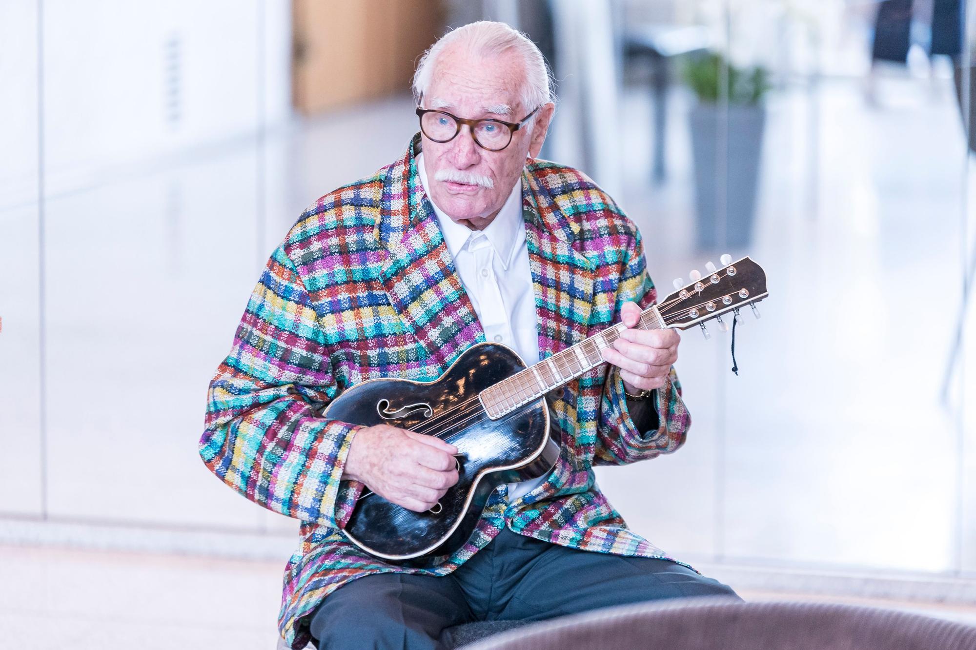 Hans Süper hölt eine Gitarre in seiner Hand