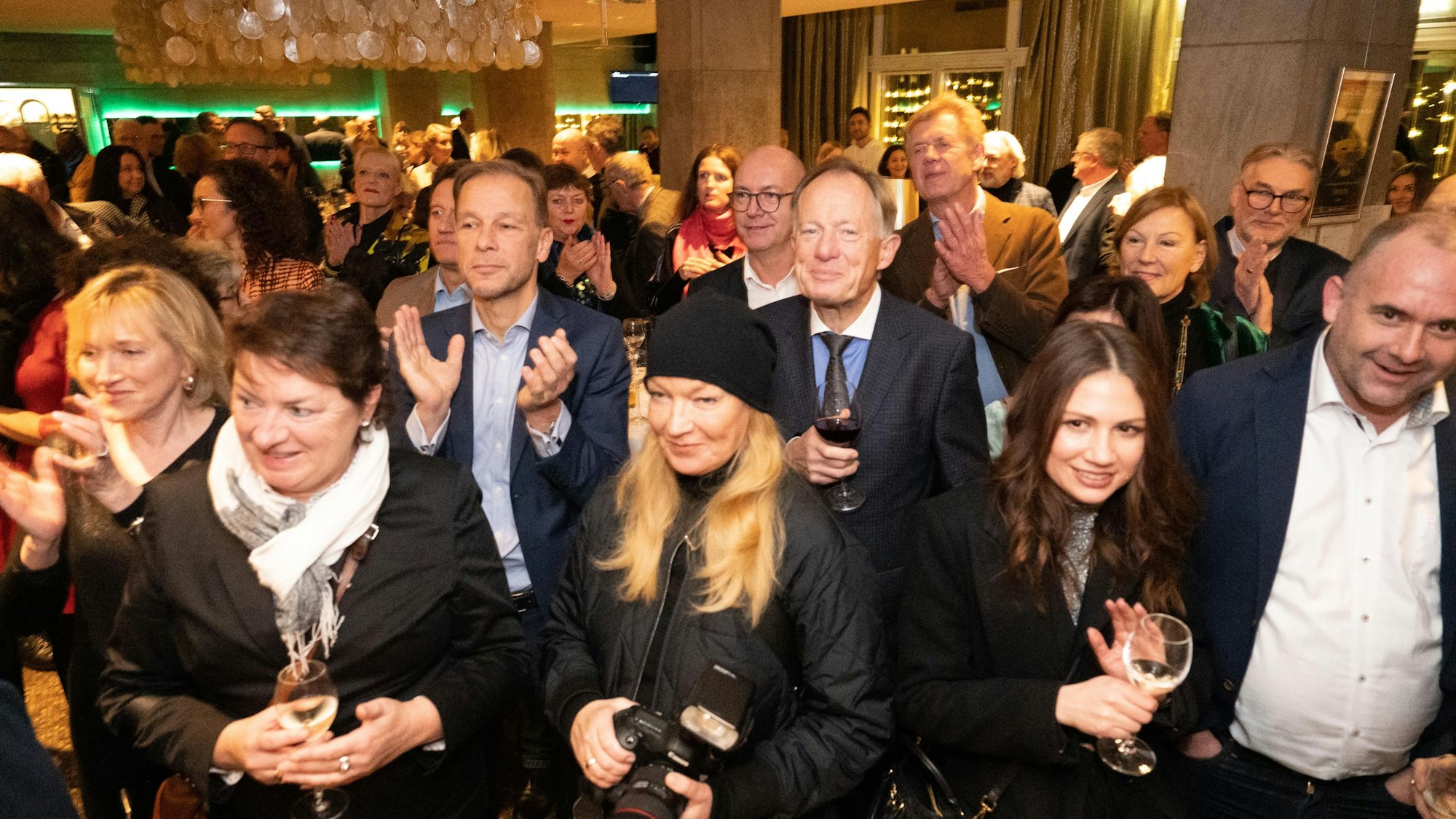 Viele Gäste lauschen einer Ansprache im Consilium und applaudieren.