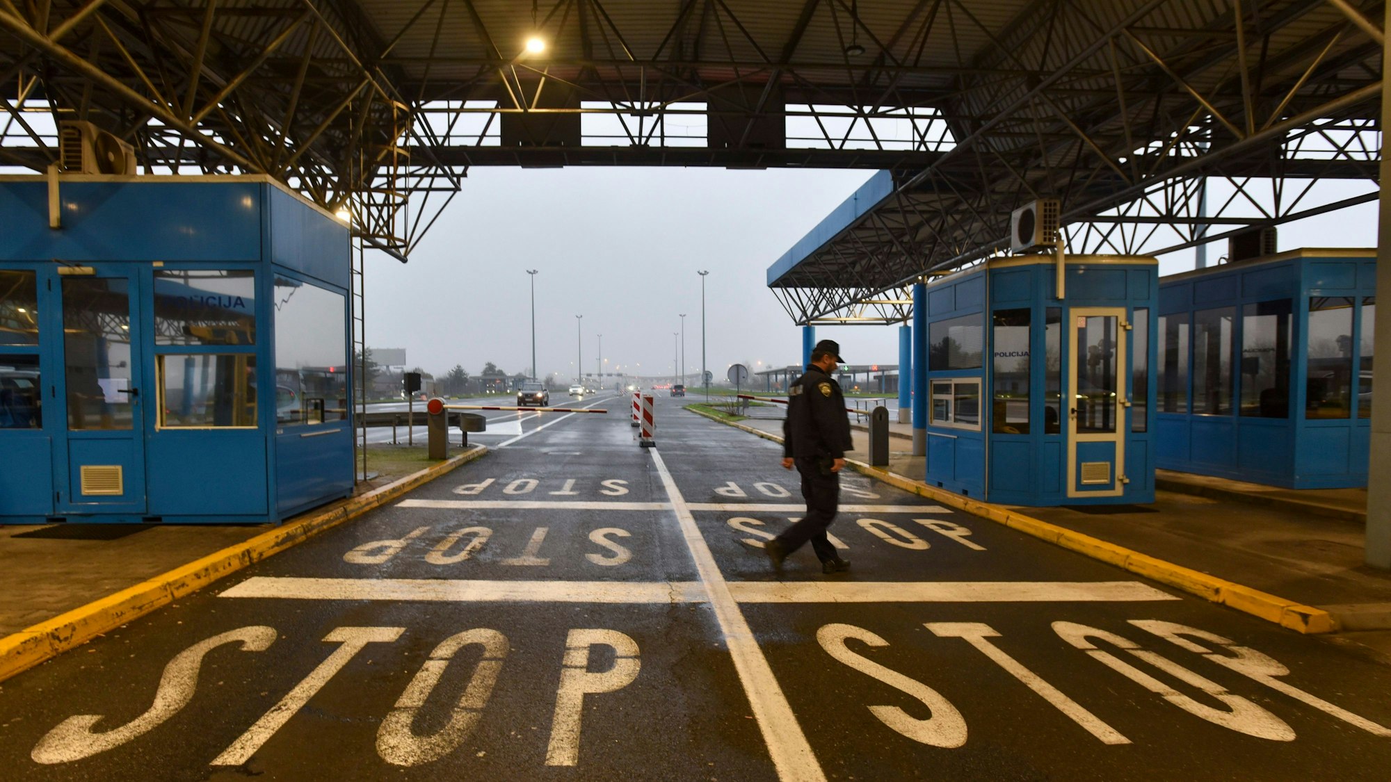 Ein kroatischer Grenzpolizist überquert die Straße an der Grenze zwischen Kroatien und Slowenien am Grenzübergang Bregana.