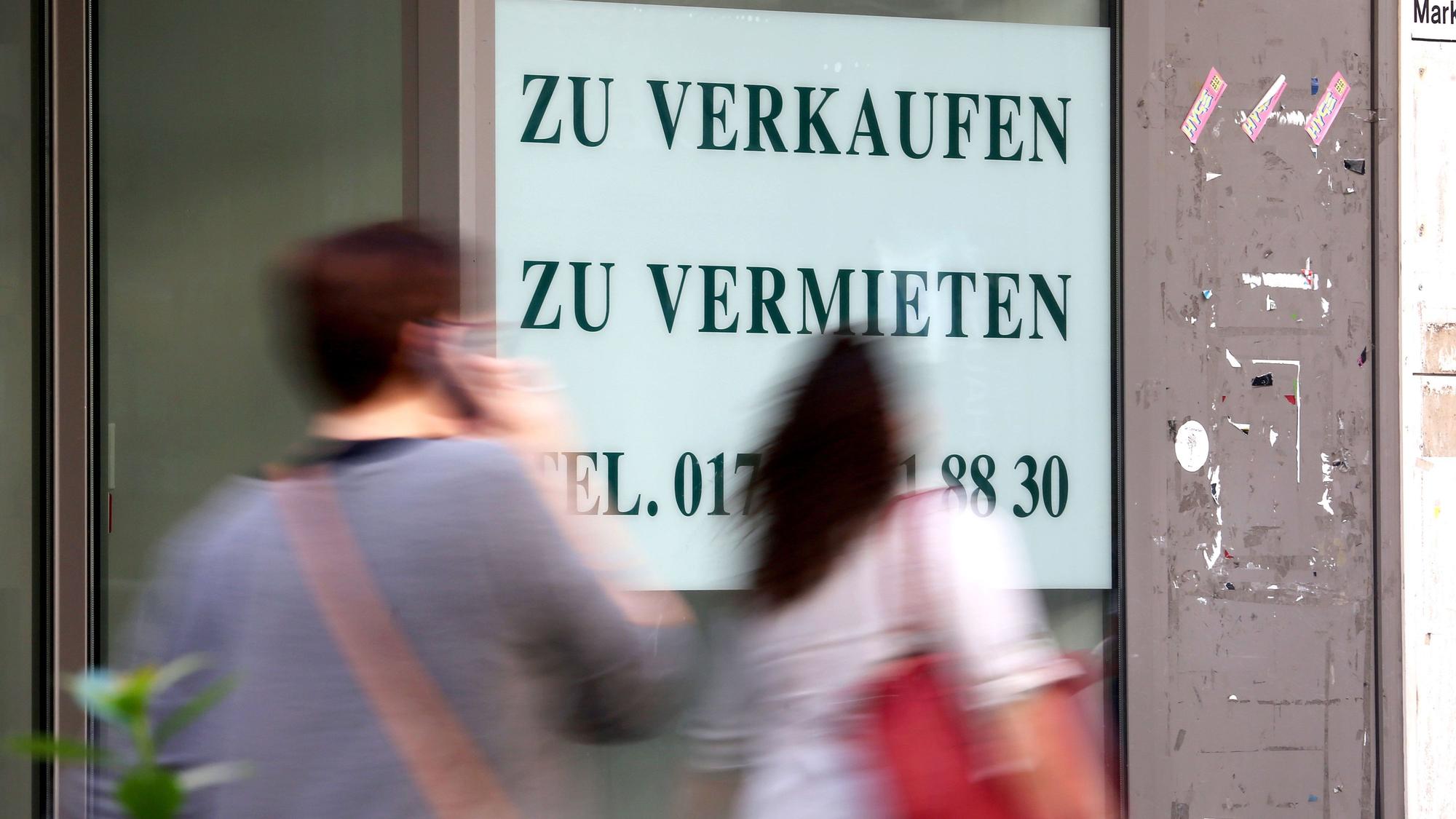 An einem Schaufenster klebt ein großer Zettel mit der Aufschrift zu Verkaufen, zu vermieten.