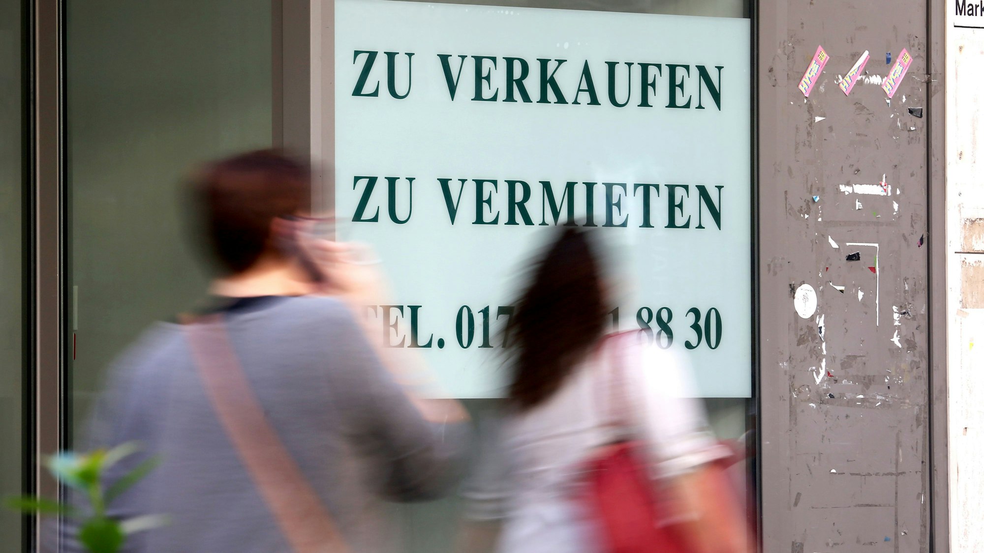 An einem Schaufenster klebt ein großer Zettel mit der Aufschrift zu Verkaufen, zu vermieten.