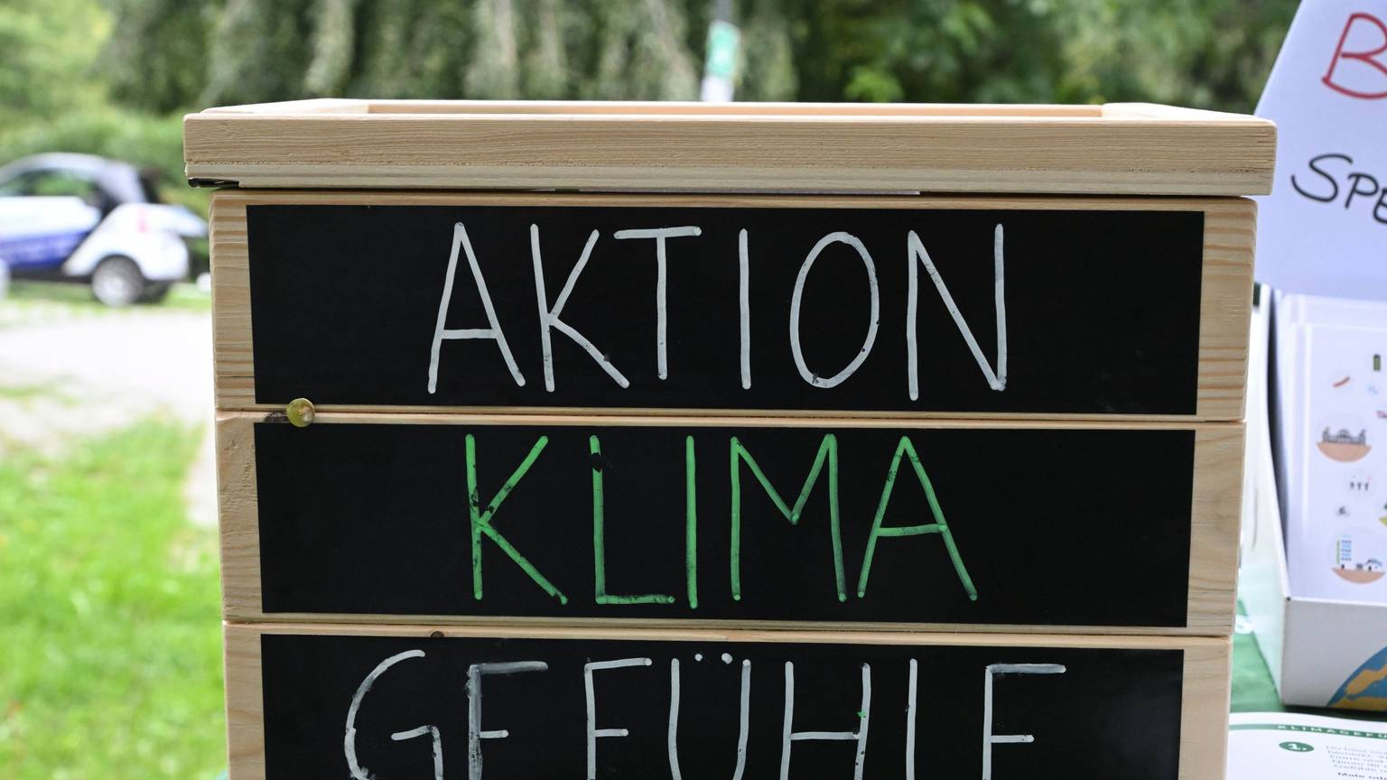 Ein Holzkasten mit der Aufschrift auf schwarzem Grund: „Aktion, Klima, Gefühle“