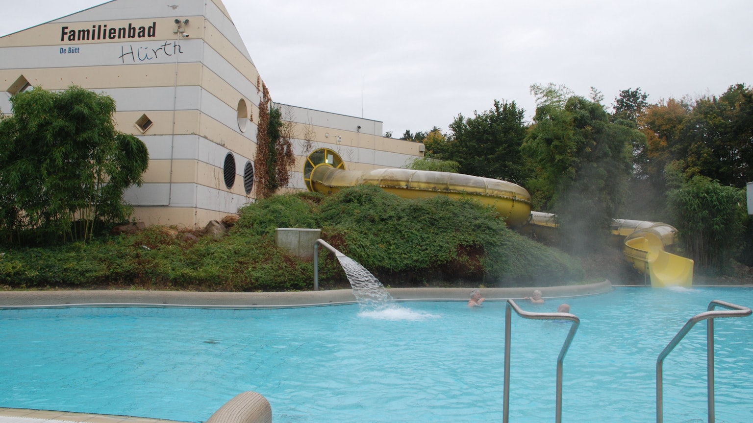 Das Bild zeigt das Außenbecken mit Rutsche im Familienbad De Bütt in Hürth.