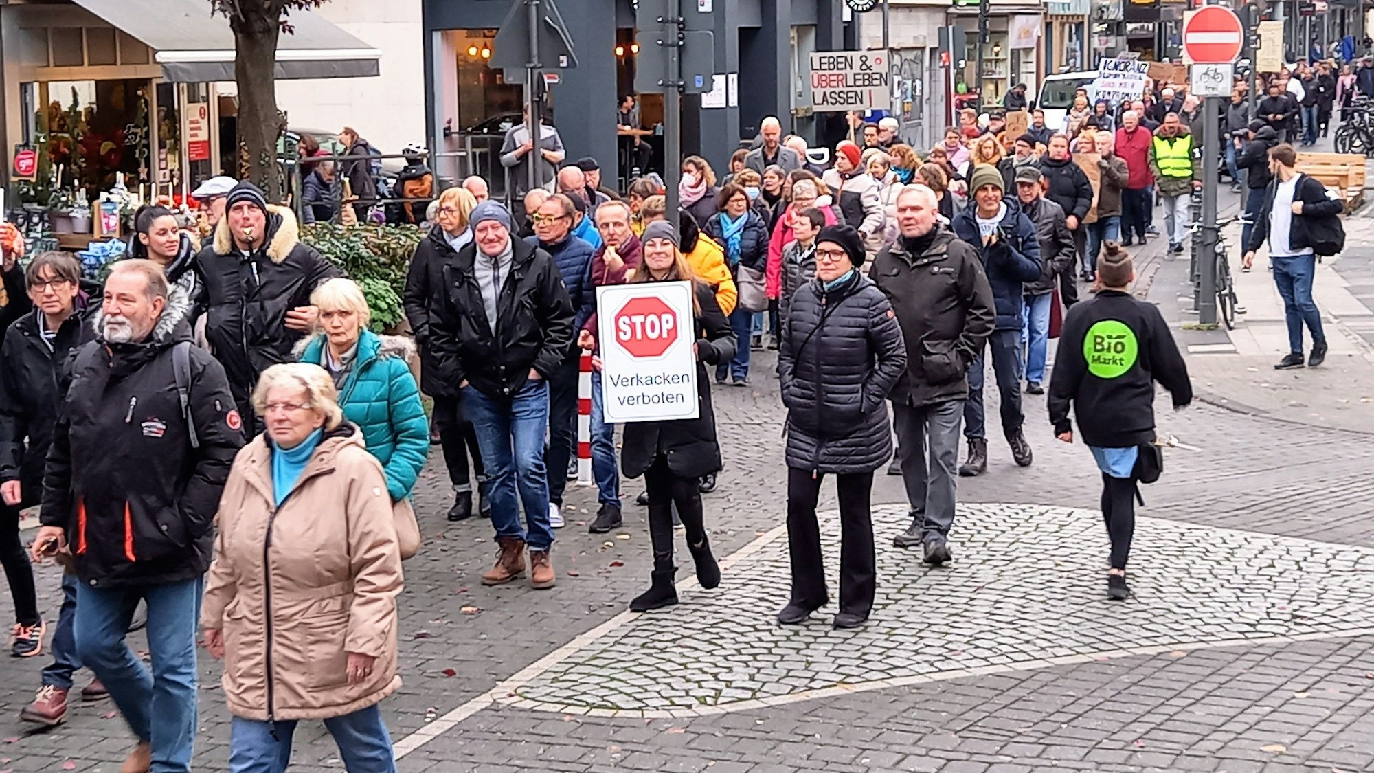 Demonstranten ziehen mit Transparenten über die Deutzer Freiheit.