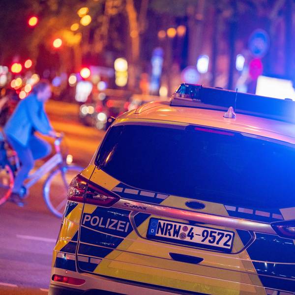 Ein Polizeiwagen fährt mit Blaulicht über eine Straße.
