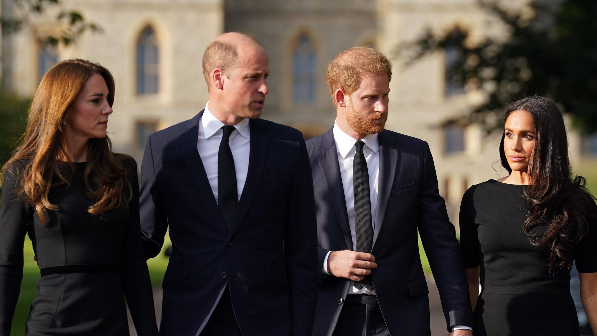 Kate, Prinzessin von Wales, William, Prinz von Wales, Prinz Harry, Herzog von Sussex, und seine Frau Meghan, Herzogin von Sussex, laufen vor dem Schloss Windsor einen Weg entlang.