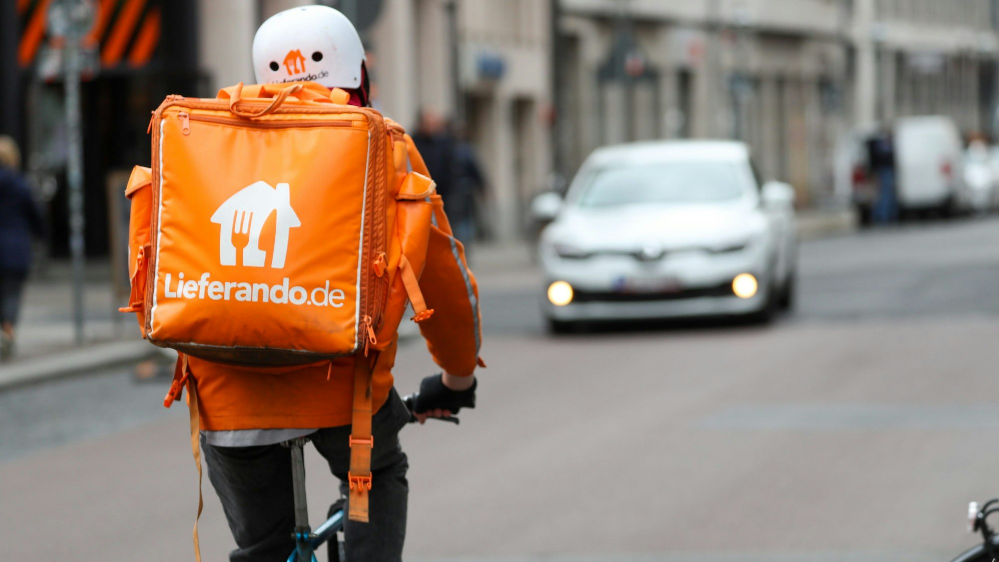 Ein Fahrradbote vom Lieferdienst „Lieferando.de“ fährt durch eine Innenstadt.