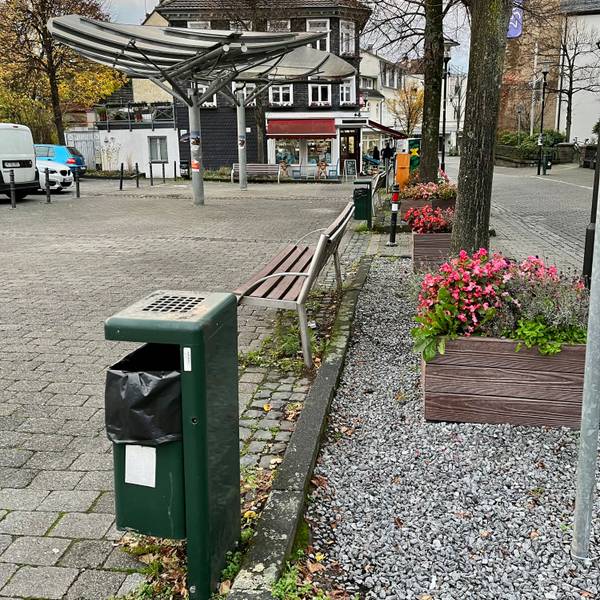 Ein Platz an der Hauptstraße in Burscheid mit Papierkörben und Bänken