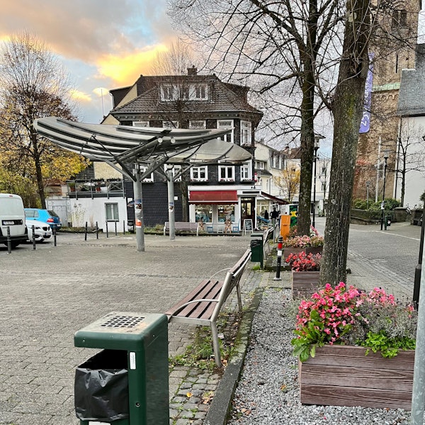 Ein Platz an der Hauptstraße in Burscheid mit Papierkörben und Bänken