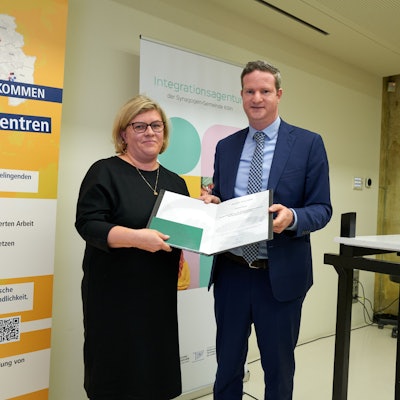 Aron Schuster, Vorsitzender der Zentralwohlfahrtsstelle der Juden in Deutschland, überreicht die Urkunde mit dem Bilz-Preis der Geschäftsführerin der Begegnungsstelle Porz Natalia Töpfer.