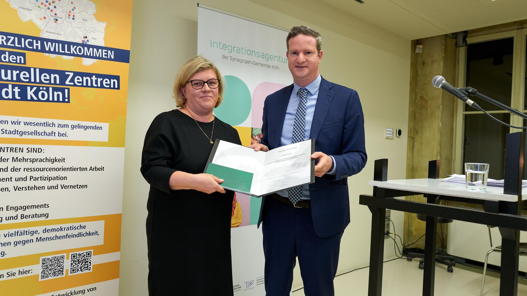 Aron Schuster, Vorsitzender der Zentralwohlfahrtsstelle der Juden in Deutschland, überreicht die Urkunde mit dem Bilz-Preis der Geschäftsführerin der Begegnungsstelle Porz Natalia Töpfer.