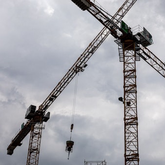 Das Bild zeigt zwei Baukräne auf einer Baustelle in der Innenstadt.