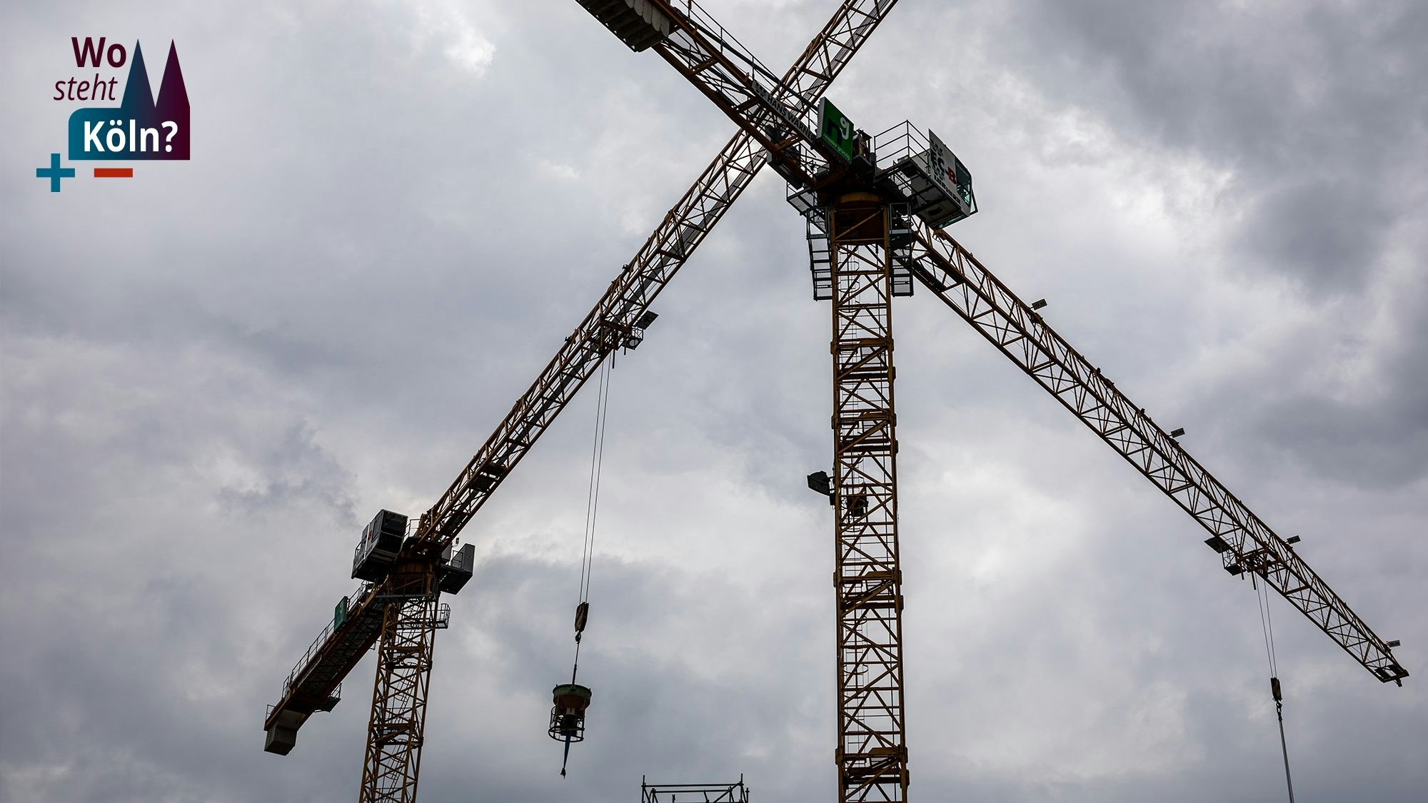 Das Bild zeigt zwei Baukräne auf einer Baustelle in der Innenstadt.