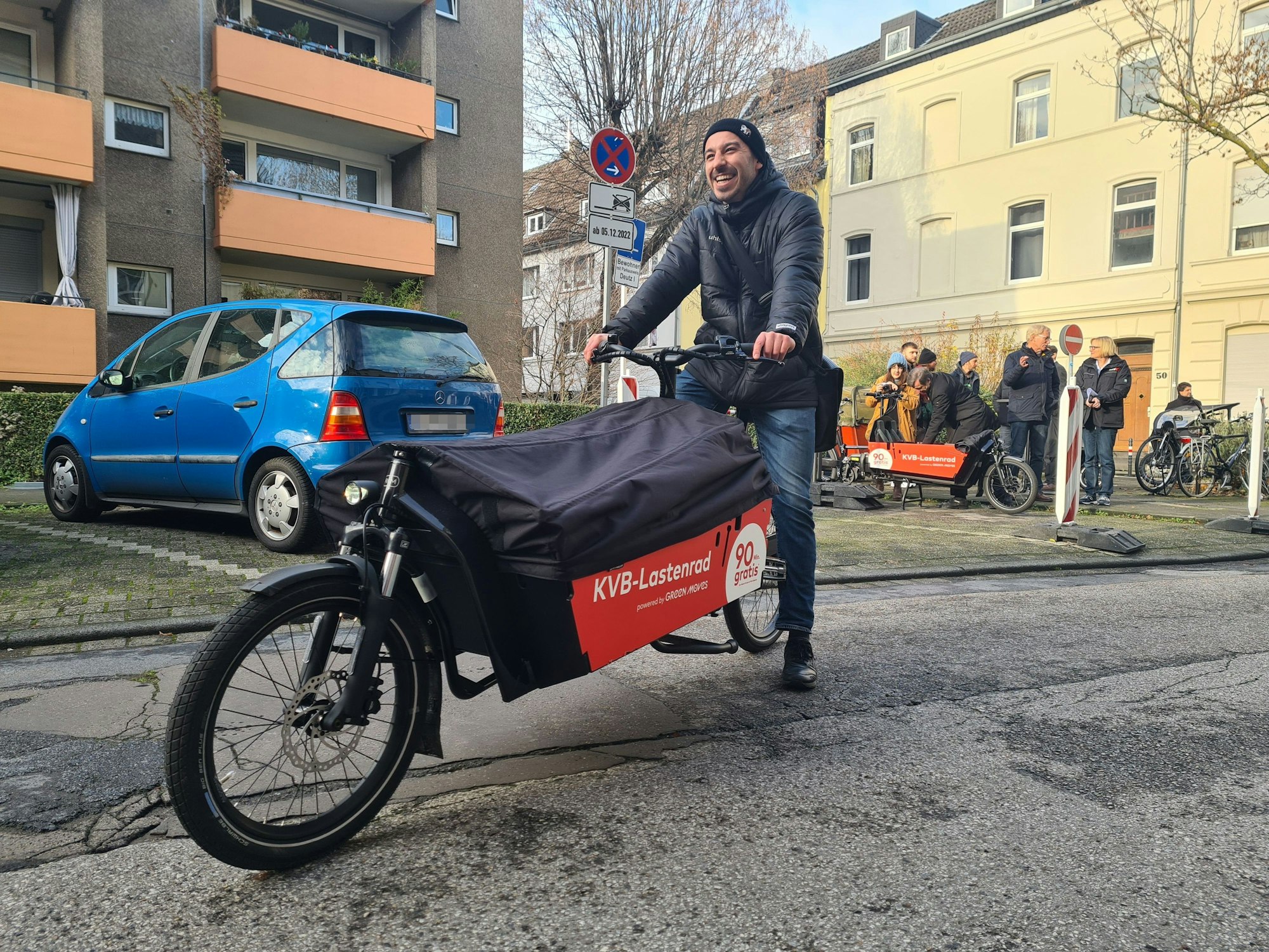 KVB präsentiert in Deutz KVB-Lastenrad als neues Angebot in Köln. Ein Mann sitzt lachend auf dem Rad.
