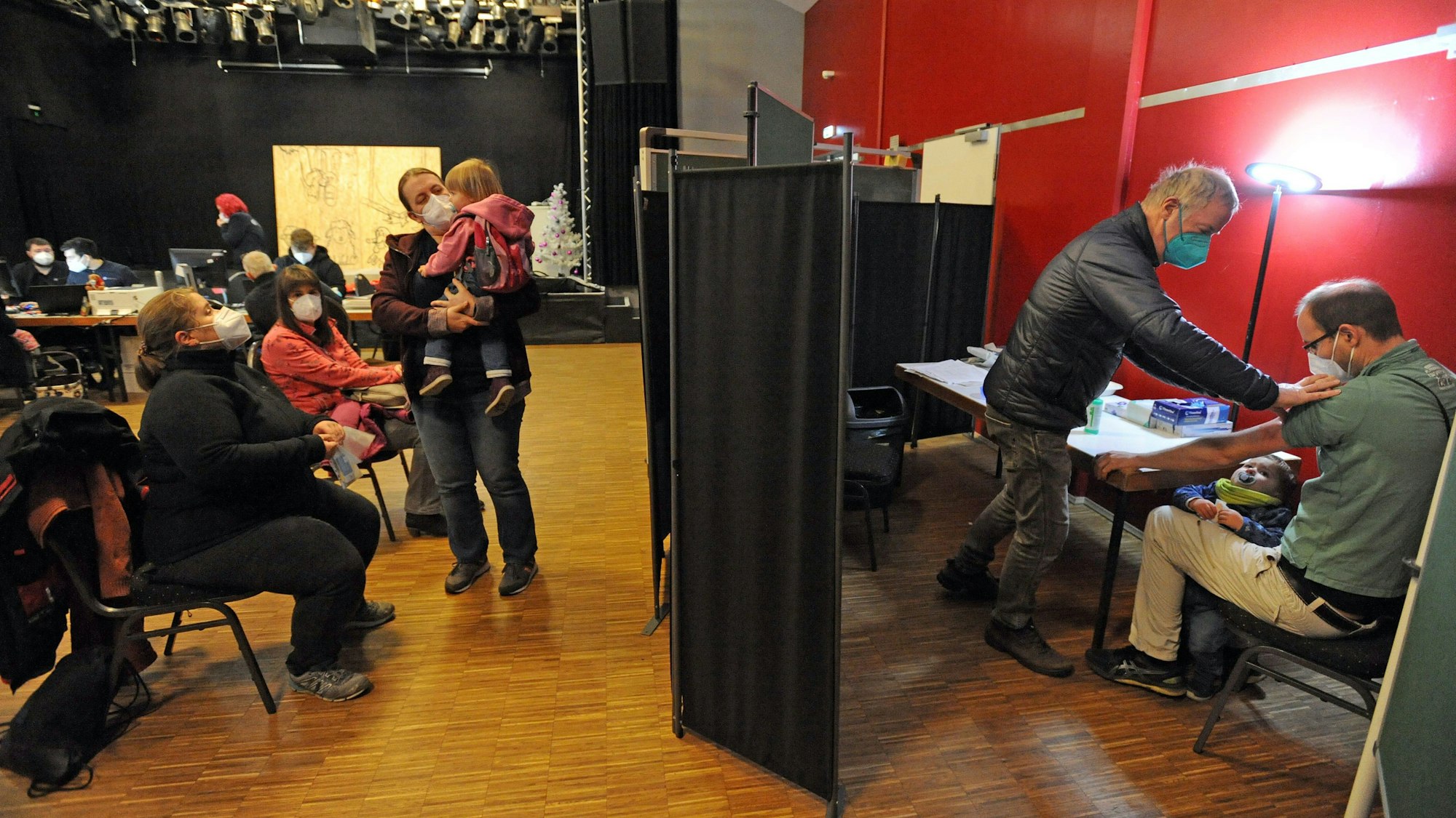 Im Burscheider wird ein Mann hinter einem Paravent gegen das Corona-Virus geimpft