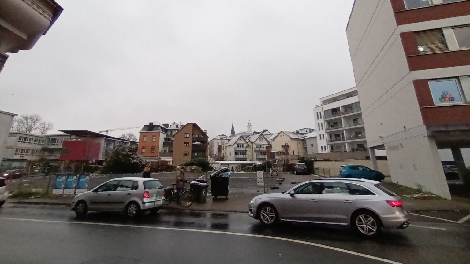 Zwei Autos fahren auf der Straße an dem Baugrundstück in der Sieburger Innenstadt an der Wilhelmstraße vorbei. Das Grundstück liegt zwischen Wohn- und Bürogebäuden und dem Gymnasium Alleestraße.